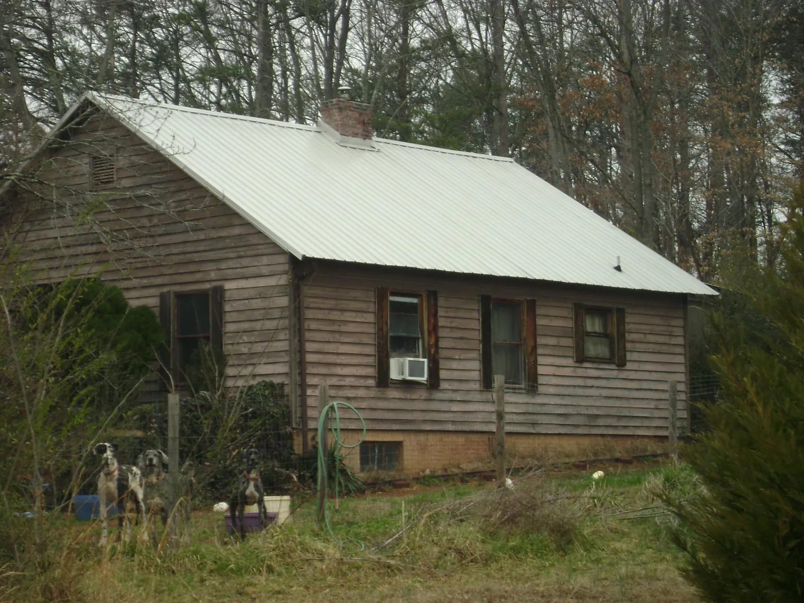 White metal roof on an old wood sided farmhouse, from a Asphalt Shingle Roof Repair job in Howard